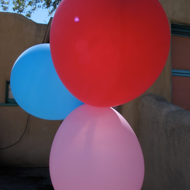 three balloons in blue, red and pink