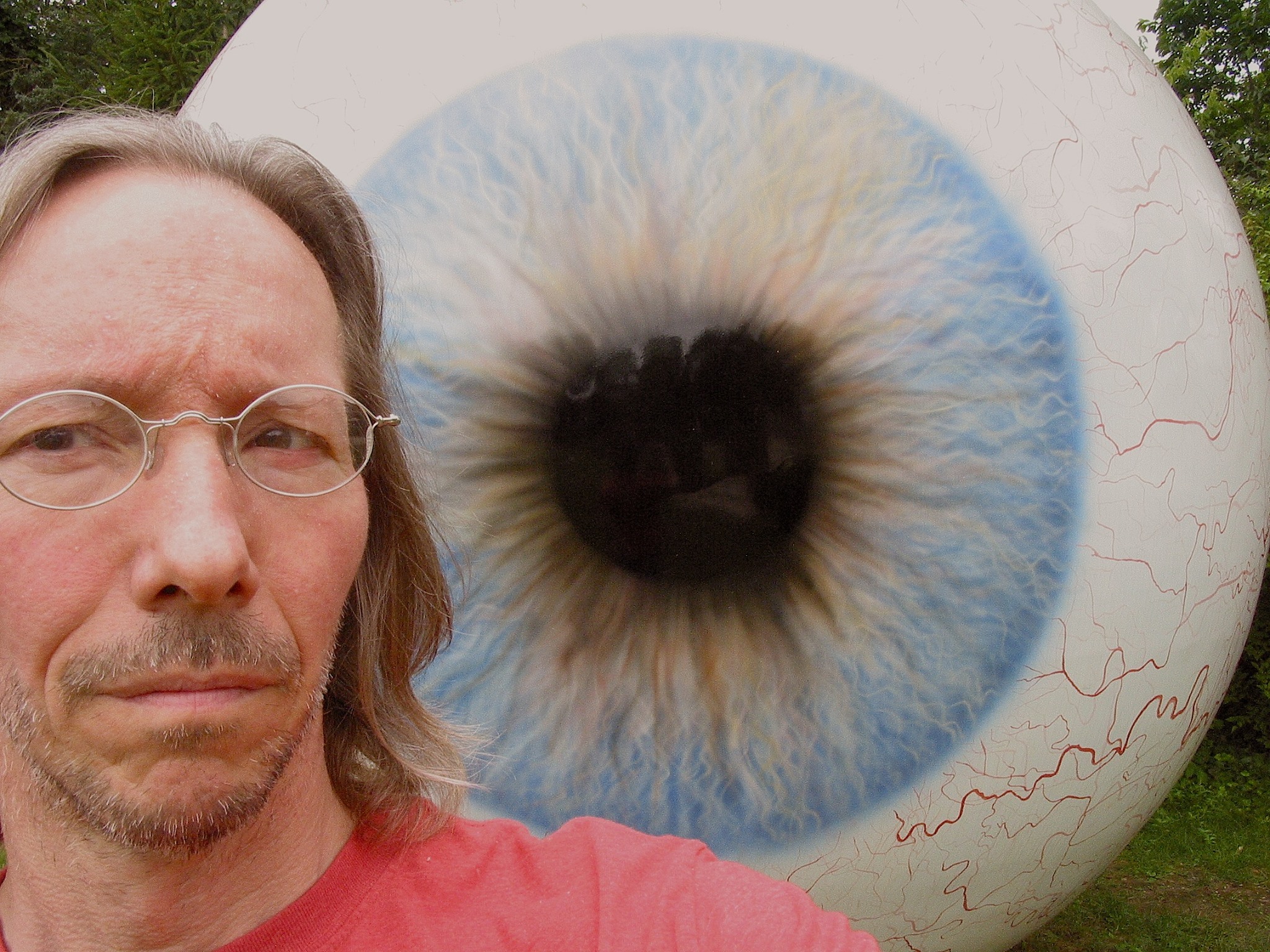 Giant eyeball outdoor sculpture with worried looking photographer