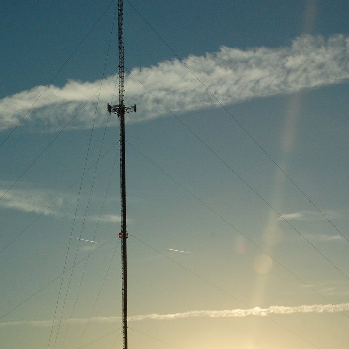 Tall communications antenna with contrails