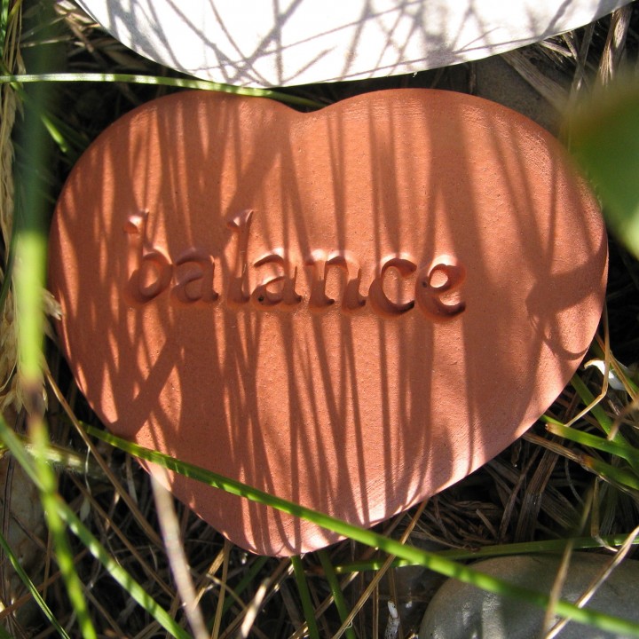 A ceramic heart with the word “balance” written on it
