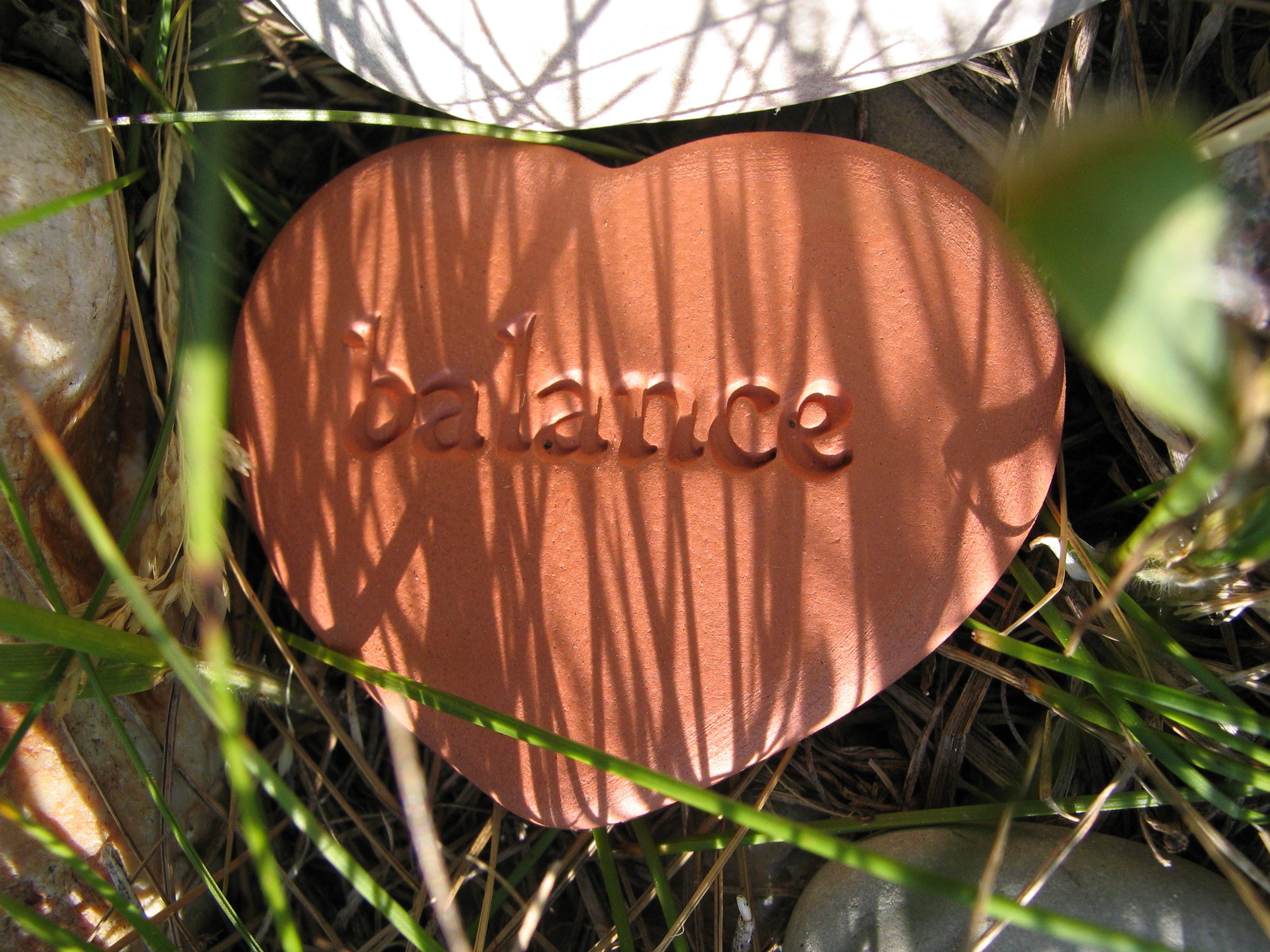 A ceramic heart with the word “balance” written on it
