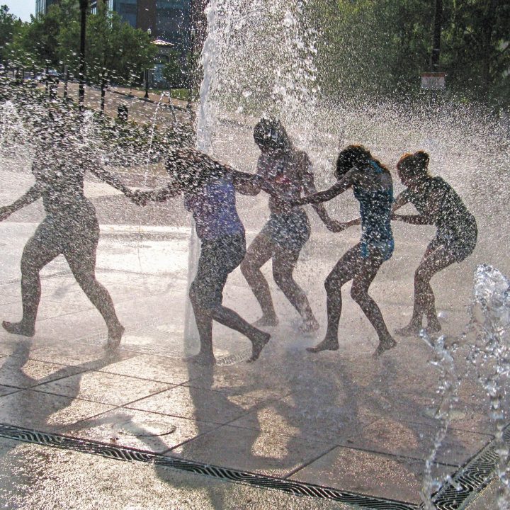 Girls running through a municipal fountain