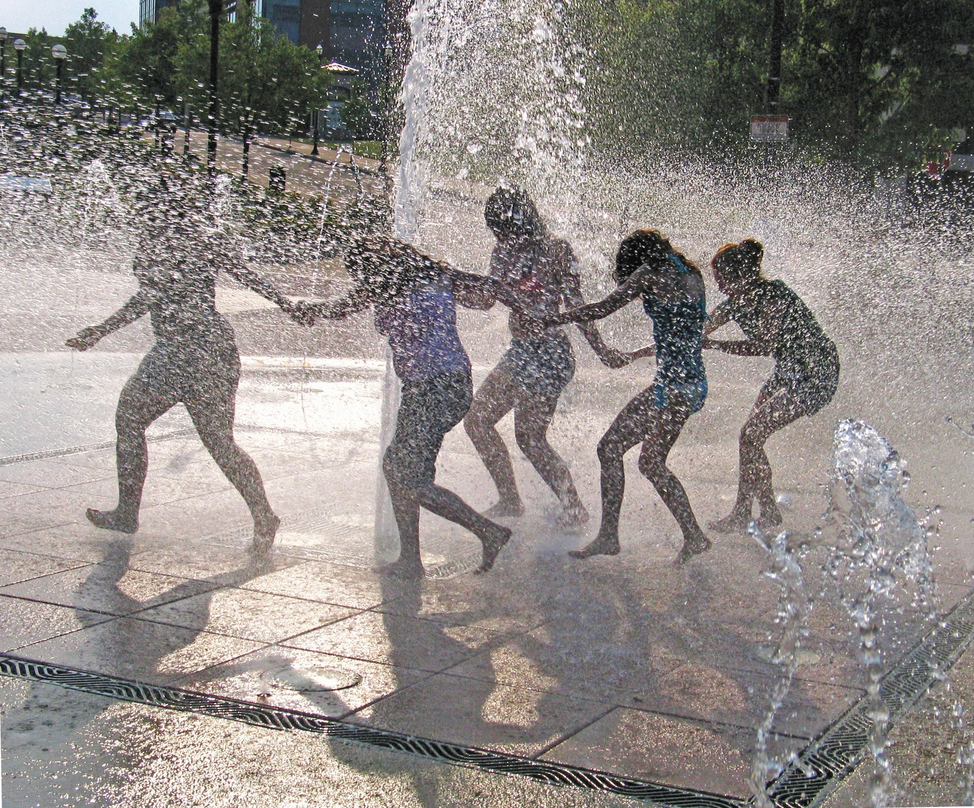 Girls running through a municipal fountain